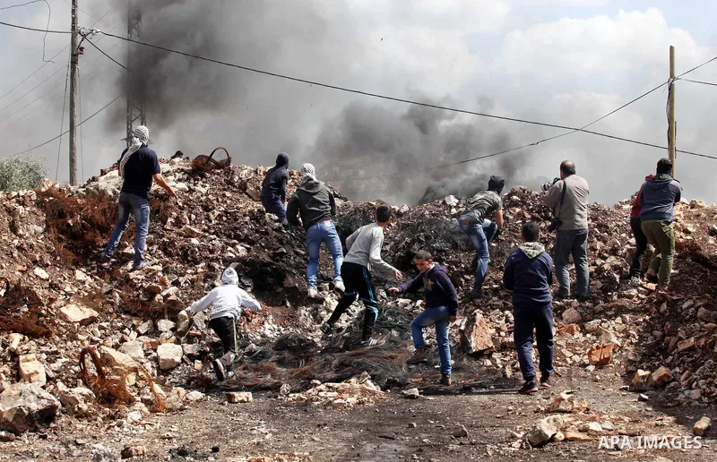 Palestinian protesters hurl stones towards Israeli security forces during clashes following a demonstration against the expropriation of Palestinian land by Israel in the village of Kfar Qaddum, near Nablus, in the occup...