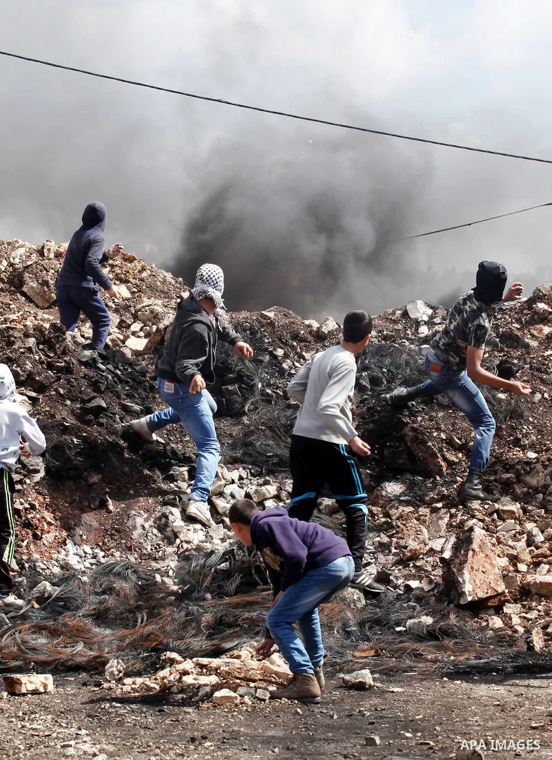 Palestinian protesters hurl stones towards Israeli security forces during clashes following a demonstration against the expropriation of Palestinian land by Israel in the village of Kfar Qaddum, near Nablus, in the occup...