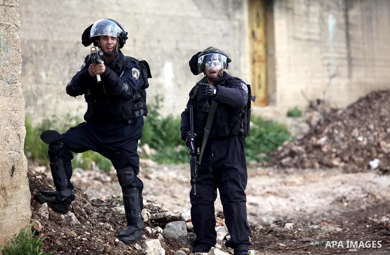 Israeli security forces aim their weapons towards Palestinian protesters during clashes following a demonstration against the expropriation of Palestinian land by Israel in the village of Kfar Qaddum, near Nablus, in the...