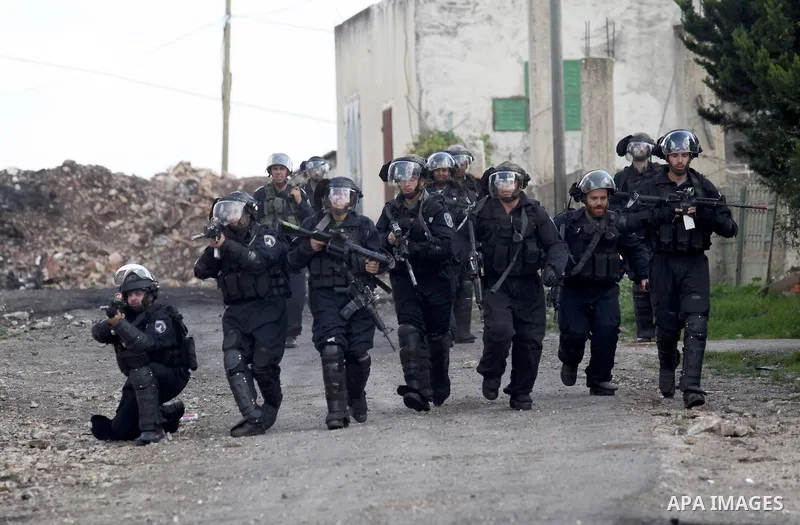 Israeli security forces aim their weapons towards Palestinian protesters during clashes following a demonstration against the expropriation of Palestinian land by Israel in the village of Kfar Qaddum, near Nablus, in the...