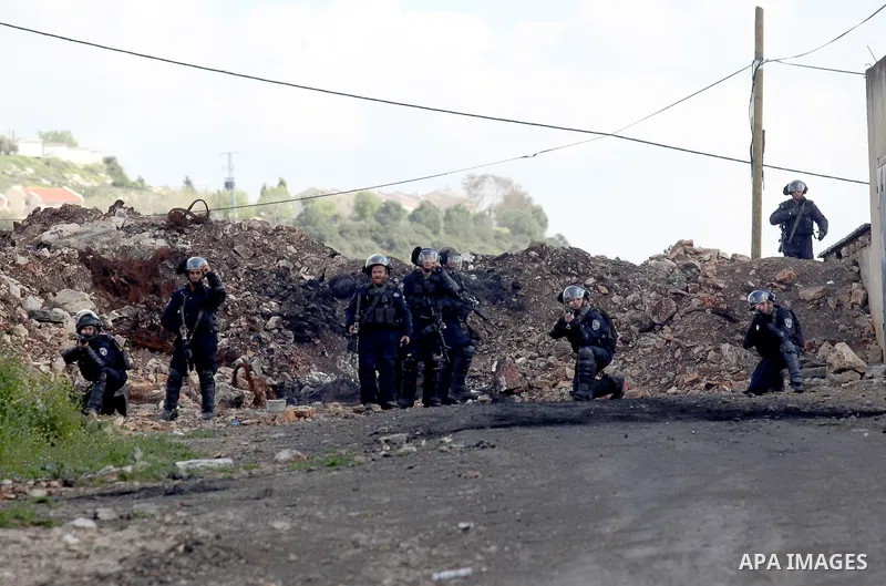 Israeli security forces aim their weapons towards Palestinian protesters during clashes following a demonstration against the expropriation of Palestinian land by Israel in the village of Kfar Qaddum, near Nablus, in the...