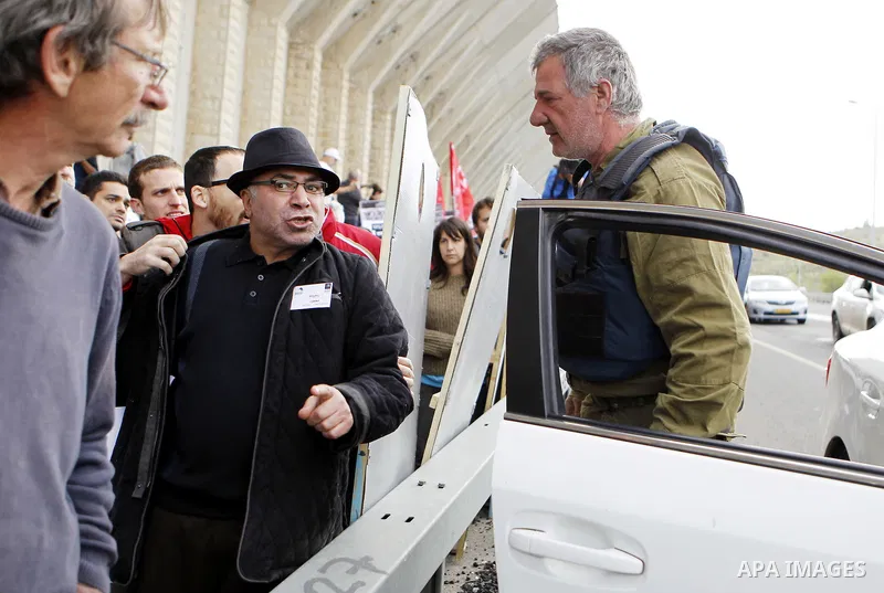 Peace activists argue with a member of Israeli security forces during a joint Israeli-Palestinian peace march along the Israeli controvertial separation wall in the West Bank city of Beit Jala between Bethlehem and Jerus...