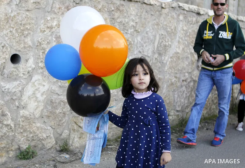 Peace activists hold placards during a joint Israeli-Palestinian peace march along the Israeli controvertial separation wall in the West Bank city of Beit Jala between Bethlehem and Jerusalem, on March 4, 2016. Peace act...