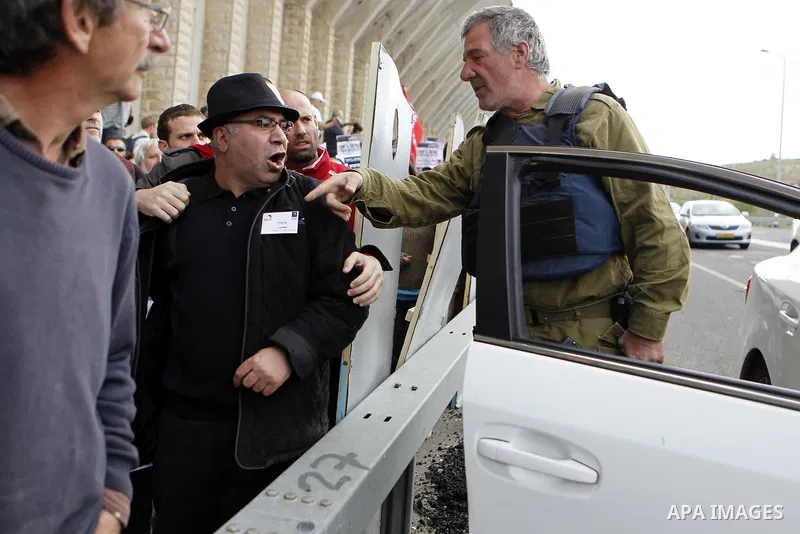 Peace activists argue with a member of Israeli security forces during a joint Israeli-Palestinian peace march along the Israeli controvertial separation wall in the West Bank city of Beit Jala between Bethlehem and Jerus...