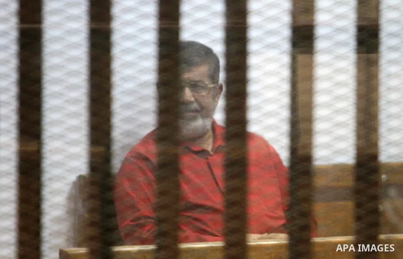 Ousted Egyptian president Mohammed Morsi sits behind bars during his trail as part of the so-called 'Qatar espionage' case, in a court in Cairo on March 06, 2016. The defendants are accused of 'leaking important national...