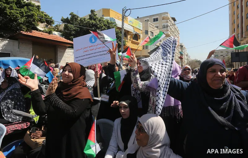 Palestinian women take part in a march in front of the headquarters of the Red cross on the occasion of International Women's Day in Gaza City on March 7, 2016. Photo by Mohammed Asad