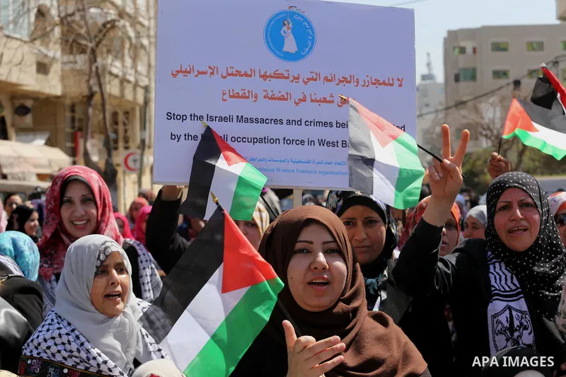 Palestinian women take part in a march in front of the headquarters of the Red cross on the occasion of International Women's Day in Gaza City on March 7, 2016. Photo by Mohammed Asad