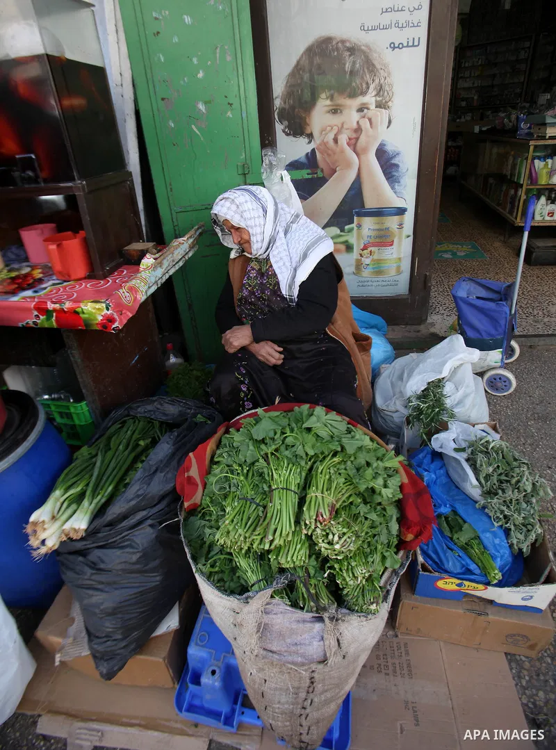 A Palestinian woman sells vegetables at a market, in the West Bank city of Nablus, on March 8, 2016. People around the globe celebrate International Women's Day, which dates back to the beginning of the 20th Century and...