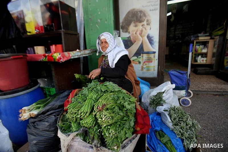 A Palestinian woman sells vegetables at a market, in the West Bank city of Nablus, on March 8, 2016. People around the globe celebrate International Women's Day, which dates back to the beginning of the 20th Century and...