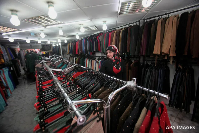 A Palestinian woman sells clothes at a shop, in the West Bank city of Nablus, on March 8, 2016. People around the globe celebrate International Women's Day, which dates back to the beginning of the 20th Century and has b...