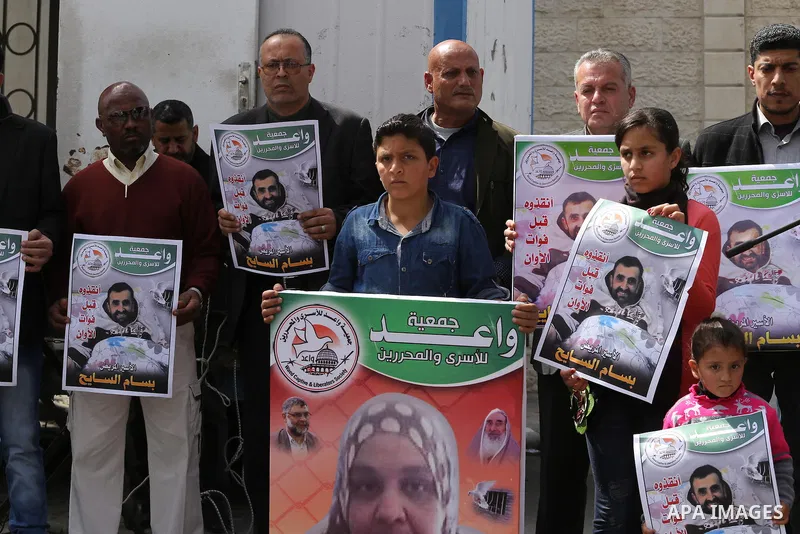 Palestinians hold placards during a protest in solidarity with Palestinian prisoners in Israeli jails, in front of high commissioner for human rights headquarters, in Gaza City on March 9, 2016. Photo by Mohammed Asad