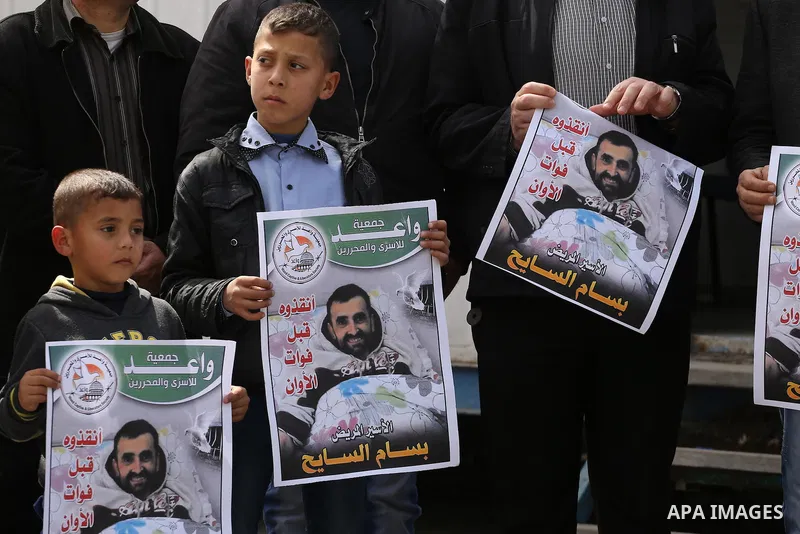 Palestinians hold placards during a protest in solidarity with Palestinian prisoners in Israeli jails, in front of high commissioner for human rights headquarters, in Gaza City on March 9, 2016. Photo by Mohammed Asad