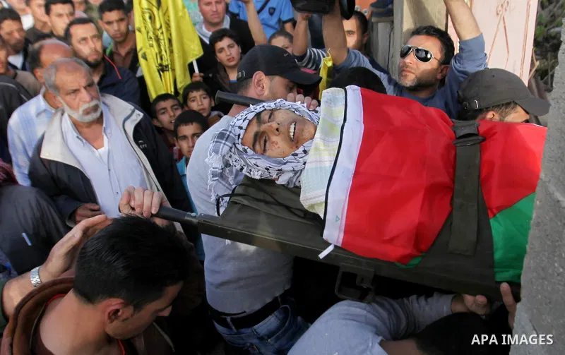 Mourners carry the body of Palestinian Ahmad Aamer, 16, who the Israeli military said was shot dead by Israeli soldiers after he tried to stab them, during his funeral in the West Bank village of Mas'ha near Salfit March...