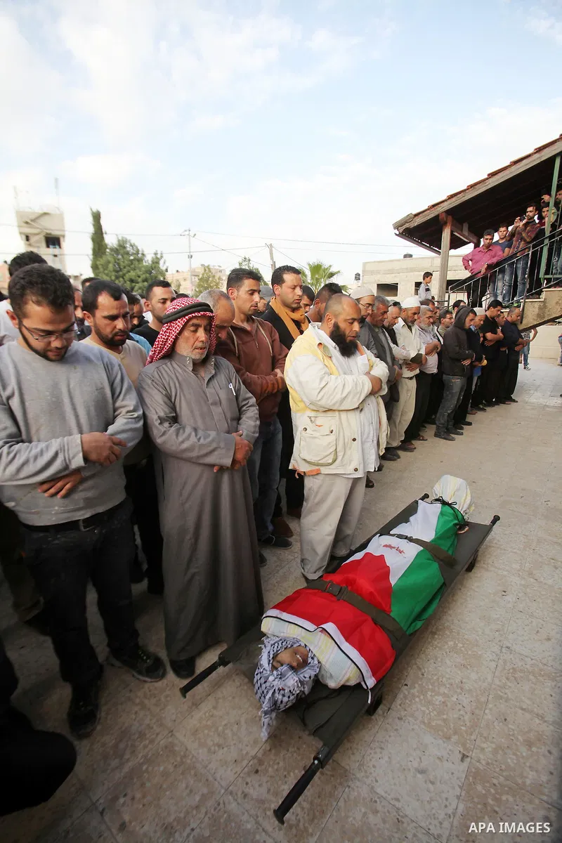Mourners pray in front of body of Palestinian Ahmad Aamer, 16, who the Israeli military said was shot dead by Israeli soldiers after he tried to stab them, during his funeral in the West Bank village of Mas'ha near Salfi...