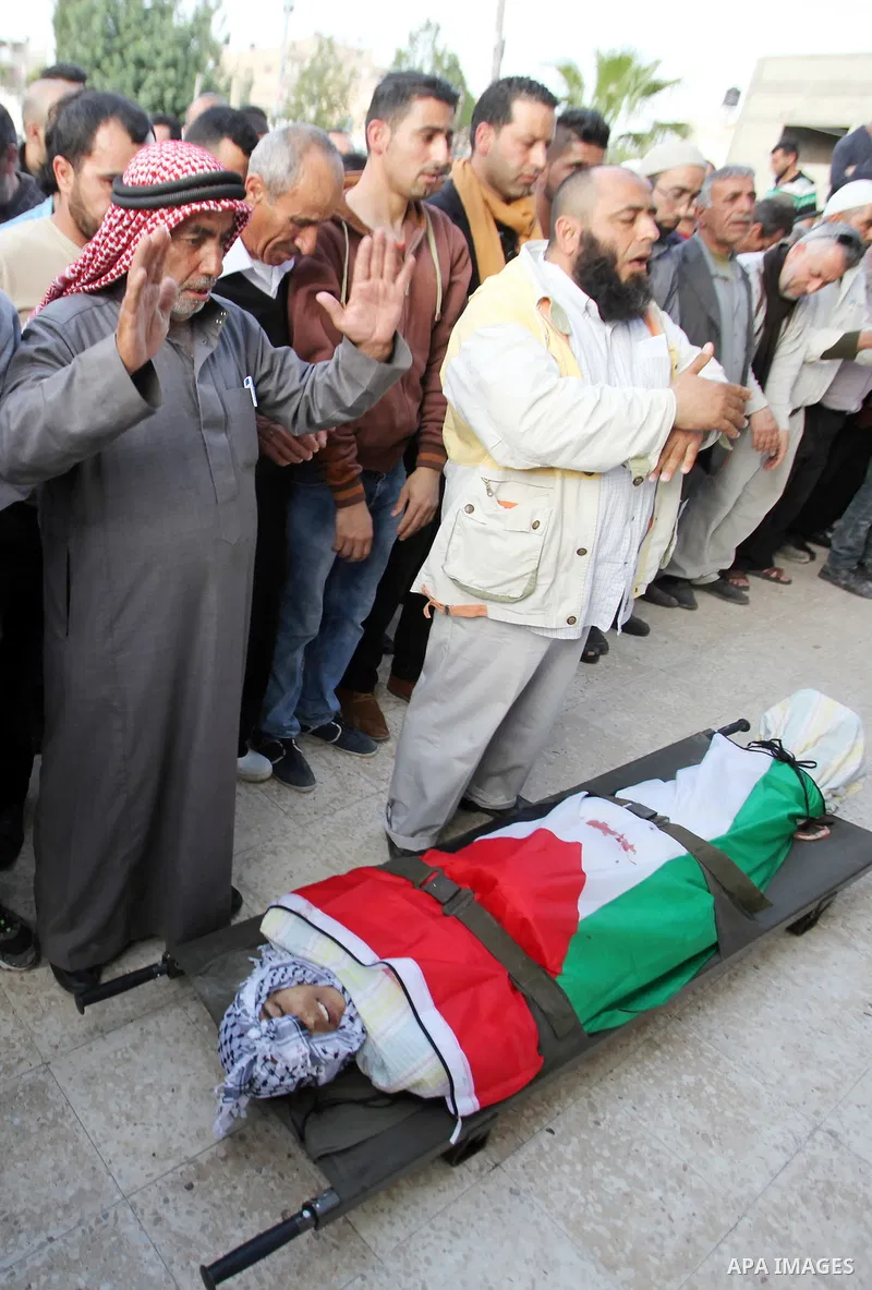 Mourners pray in front of body of Palestinian Ahmad Aamer, 16, who the Israeli military said was shot dead by Israeli soldiers after he tried to stab them, during his funeral in the West Bank village of Mas'ha near Salfi...