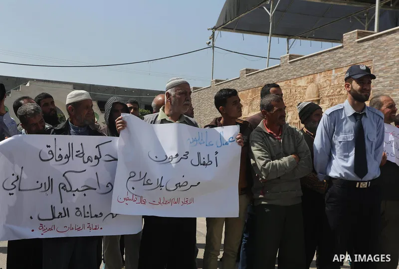Palestinian laborers hold banners as they take part in a protest to demanding their rights, in front of the Legislative Council headquarters, in Gaza city, on March 10, 2016. Photo by Mohammed Asad