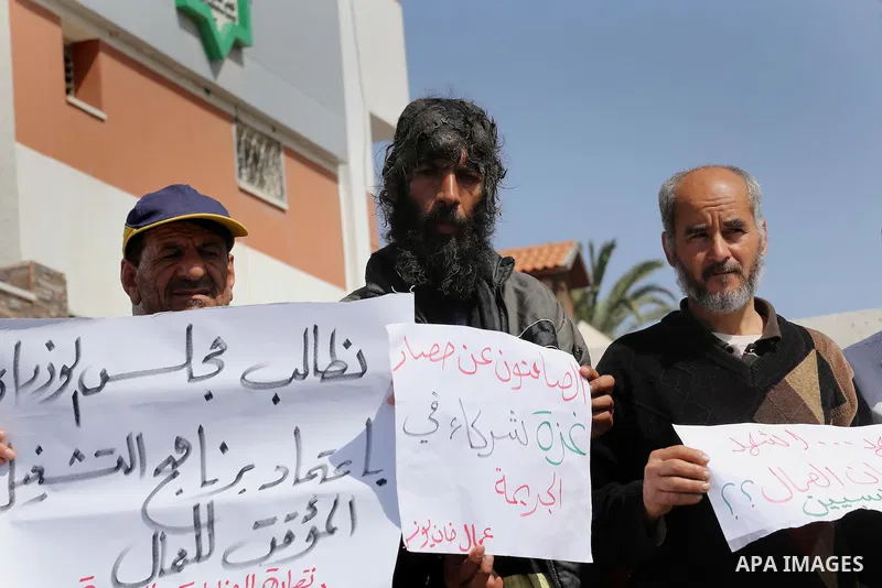 Palestinian laborers hold banners as they take part in a protest to demanding their rights, in front of the Legislative Council headquarters, in Gaza city, on March 10, 2016. Photo by Mohammed Asad