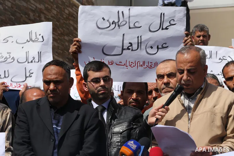 Palestinian laborers hold banners as they take part in a protest to demanding their rights, in front of the Legislative Council headquarters, in Gaza city, on March 10, 2016. Photo by Mohammed Asad