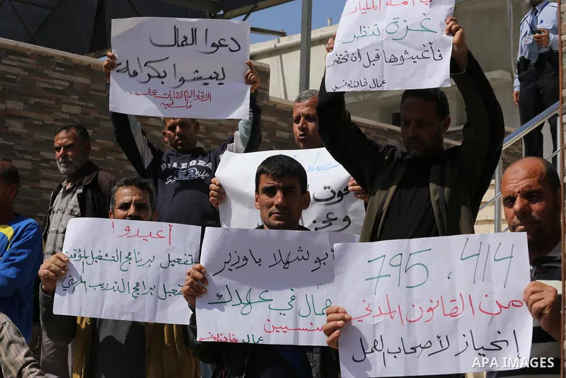 Palestinian laborers hold banners as they take part in a protest to demanding their rights, in front of the Legislative Council headquarters, in Gaza city, on March 10, 2016. Photo by Mohammed Asad