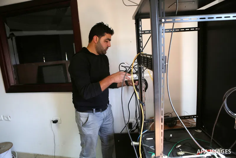 Palestinian employees of Palestine Today television inspect the damage at the station's offices after it had been raided by Israeli forces overnight on March 11, 2016, in the West Bank city of Ramallah. Israeli forces ra...