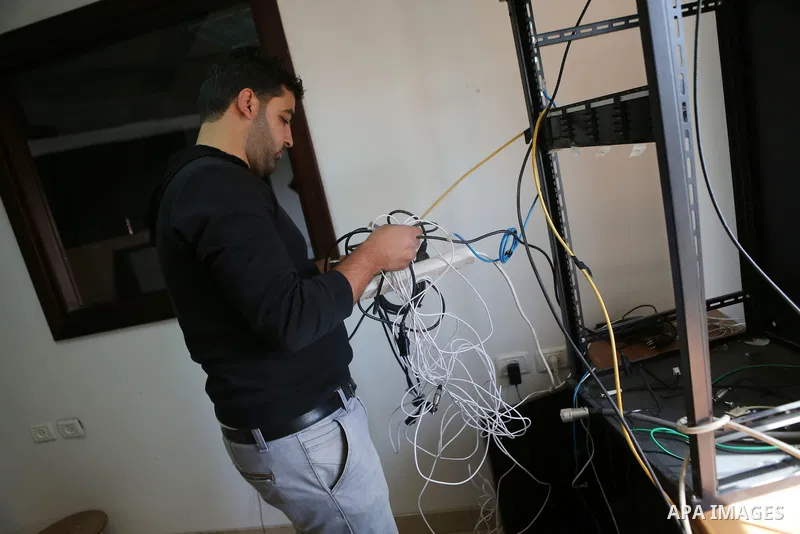 Palestinian employees of Palestine Today television inspect the damage at the station's offices after it had been raided by Israeli forces overnight on March 11, 2016, in the West Bank city of Ramallah. Israeli forces ra...
