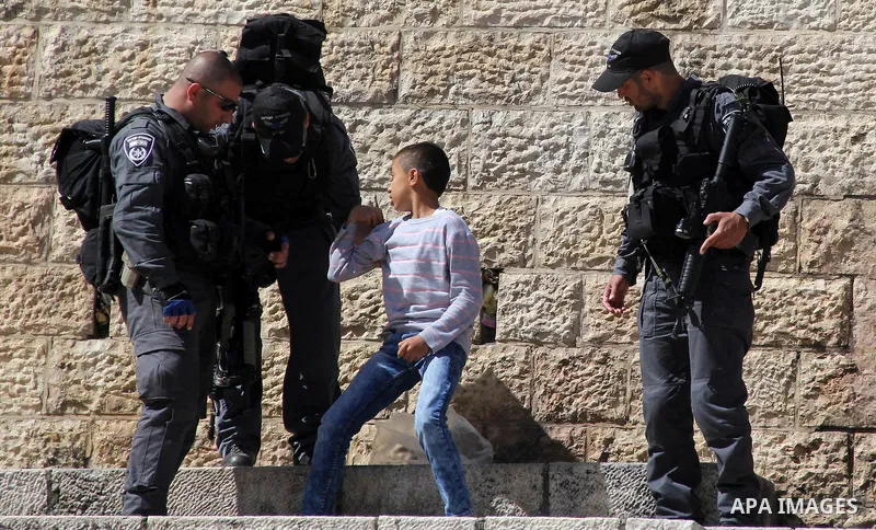 Israeli security forces frisk a Palestinian boy, in Jerusalem's Old City, on March 11, 2016. Photo by Mahfouz Abu Turk