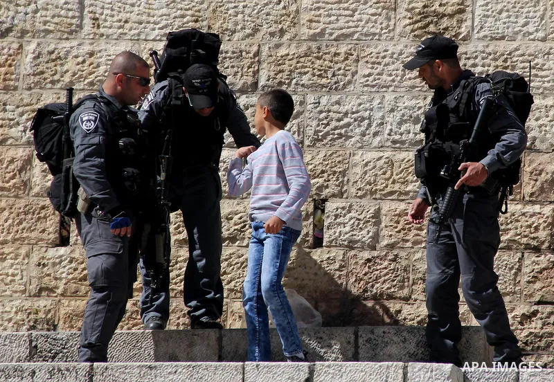 Israeli security forces frisk a Palestinian boy, in Jerusalem's Old City, on March 11, 2016. Photo by Mahfouz Abu Turk
