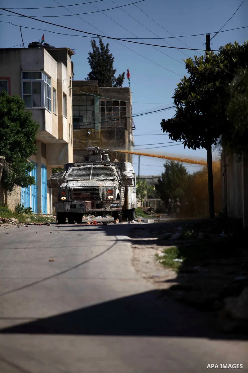 An Israeli truck sprays foul smelling water at Palestinian protesters during clashes following a demonstration against the expropriation of Palestinian land by Israel in the village of Kfar Qaddum, near Nablus, in the oc...