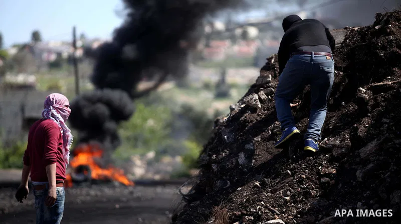 Palestinian protestors look on during clashes with Israeli security forces following a demonstration against the expropriation of Palestinian land by Israel in the village of Kfar Qaddum, near Nablus, in the occupied Wes...
