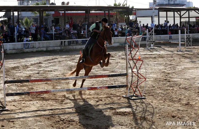 A Palestinian rider clears a jump with his horse during a jumping competition in Gaza city on March 11, 2016. Photo by Mohammed Asad