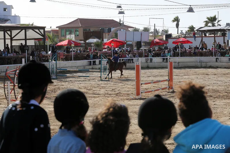 A Palestinian rider clears a jump with his horse during a jumping competition in Gaza city on March 11, 2016. Photo by Mohammed Asad