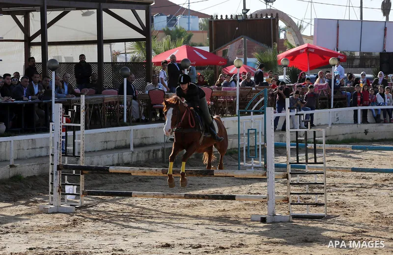 A Palestinian rider clears a jump with his horse during a jumping competition in Gaza city on March 11, 2016. Photo by Mohammed Asad