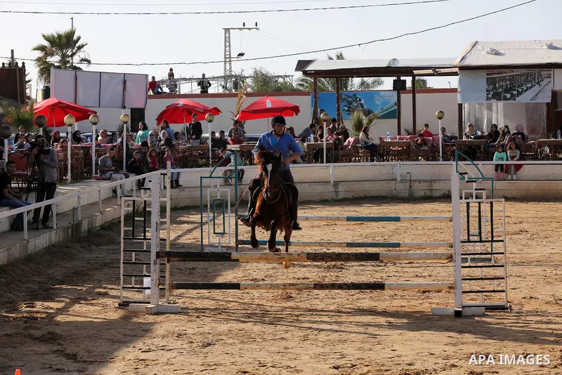 A Palestinian rider clears a jump with his horse during a jumping competition in Gaza city on March 11, 2016. Photo by Mohammed Asad