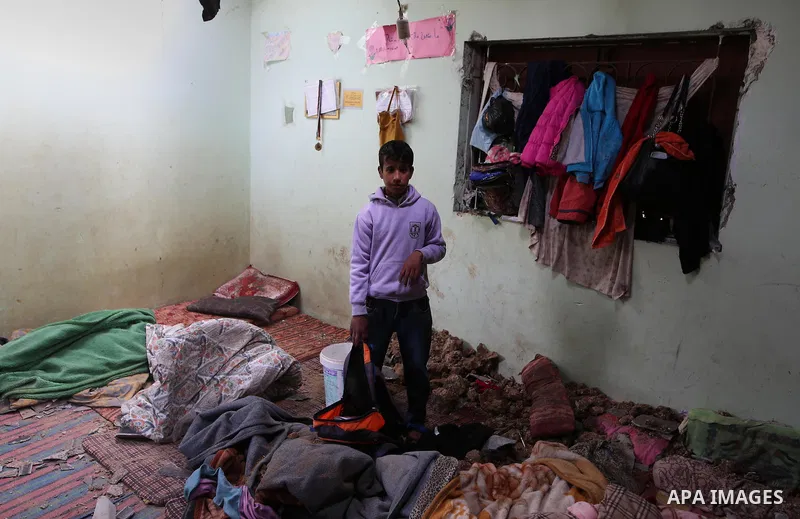 A Palestinian boy inspects a bedroom of the damaged Khussa family home after an Israeli strike on Hamas bases in Beit Lahiya, northern Gaza strip on March 12, 2016. Israeli planes struck Hamas bases in the Gaza Strip ear...