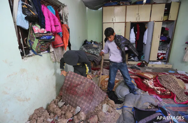 A Palestinian boy inspects a bedroom of the damaged Khussa family home after an Israeli strike on Hamas bases in Beit Lahiya, northern Gaza strip on March 12, 2016. Israeli planes struck Hamas bases in the Gaza Strip ear...