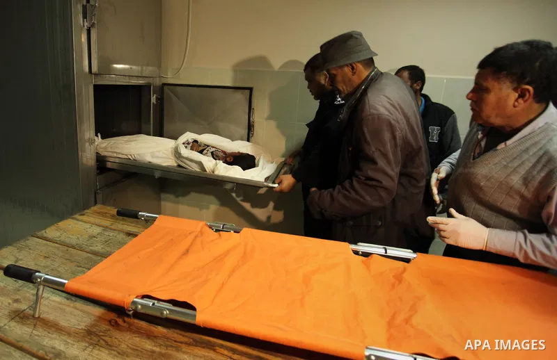 The body of Palestinian Yasin Abu Khussa, 10, lies on the bed in the morgue of a hospital following an Israeli air strike in the northern Gaza strip on March 12, 2016. Israeli planes struck Hamas bases in the Gaza Strip...