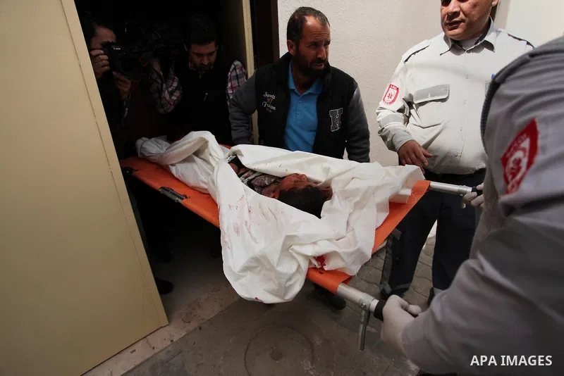 The body of Palestinian Yasin Abu Khussa, 10, lies on the bed in the morgue of a hospital following an Israeli air strike in the northern Gaza strip on March 12, 2016. Israeli planes struck Hamas bases in the Gaza Strip...