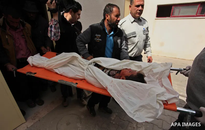 The body of Palestinian Yasin Abu Khussa, 10, lies on the bed in the morgue of a hospital following an Israeli air strike in the northern Gaza strip on March 12, 2016. Israeli planes struck Hamas bases in the Gaza Strip...