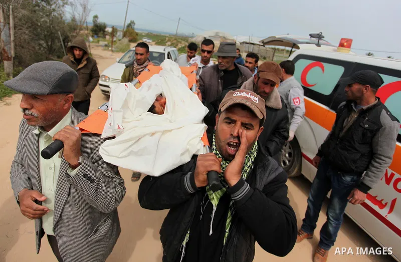 Mourners carry the body of Palestinian Yasin Abu Khussa, 10, during his funeral in the northern Gaza strip on March 12, 2016. Israeli planes struck Hamas bases in the Gaza Strip early on March 12, killing a child living...