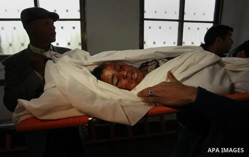 Mourners gather around the body of Palestinian Yasin Abu Khussa, 10, during his funeral in the northern Gaza strip on March 12, 2016. Israeli planes struck Hamas bases in the Gaza Strip early on March 12, killing a child...