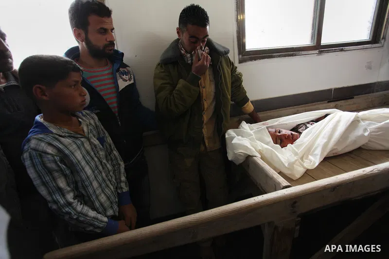 Mourners gather around the body of Palestinian Yasin Abu Khussa, 10, during his funeral in the northern Gaza strip on March 12, 2016. Israeli planes struck Hamas bases in the Gaza Strip early on March 12, killing a child...