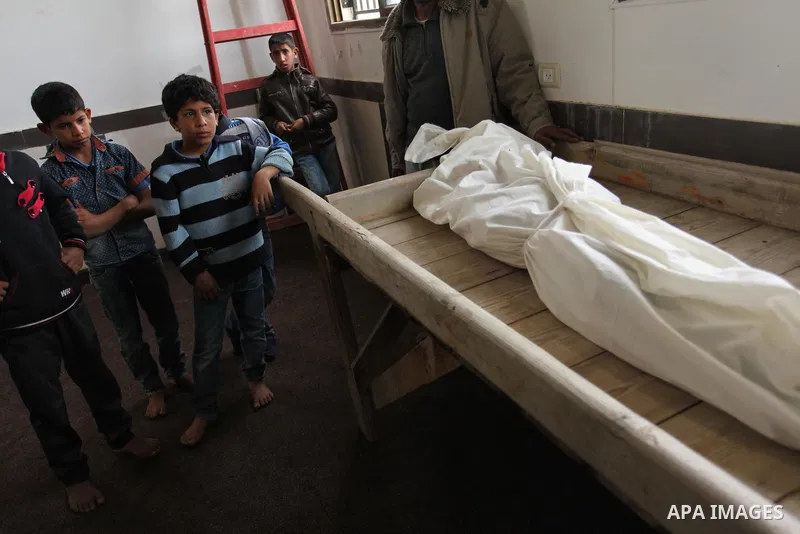 Mourners gather around the body of Palestinian Yasin Abu Khussa, 10, during his funeral in the northern Gaza strip on March 12, 2016. Israeli planes struck Hamas bases in the Gaza Strip early on March 12, killing a child...
