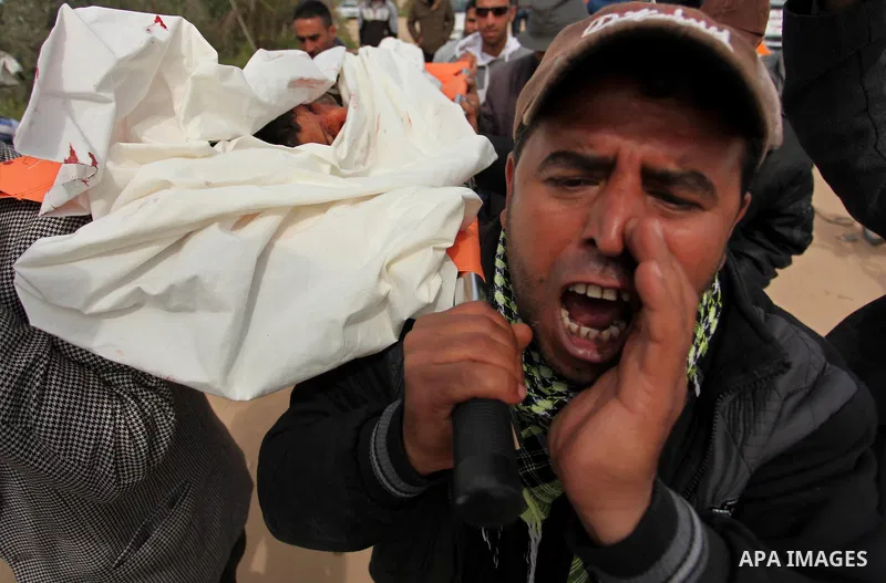 Mourners carry the body of Palestinian Yasin Abu Khussa, 10, during his funeral in the northern Gaza strip on March 12, 2016. Israeli planes struck Hamas bases in the Gaza Strip early on March 12, killing a child living...