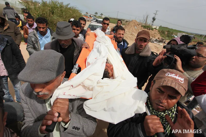 Mourners carry the body of Palestinian Yasin Abu Khussa, 10, during his funeral in the northern Gaza strip on March 12, 2016. Israeli planes struck Hamas bases in the Gaza Strip early on March 12, killing a child living...