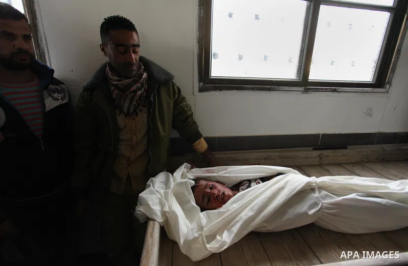 Mourners gather around the body of Palestinian Yasin Abu Khussa, 10, during his funeral in the northern Gaza strip on March 12, 2016. Israeli planes struck Hamas bases in the Gaza Strip early on March 12, killing a child...