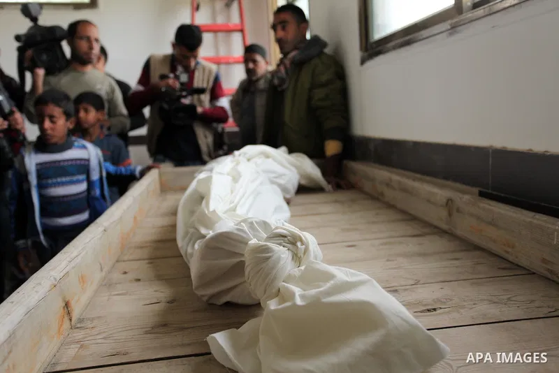 Mourners gather around the body of Palestinian Yasin Abu Khussa, 10, during his funeral in the northern Gaza strip on March 12, 2016. Israeli planes struck Hamas bases in the Gaza Strip early on March 12, killing a child...