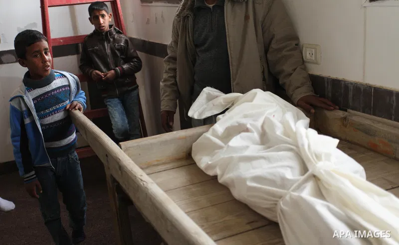 Mourners gather around the body of Palestinian Yasin Abu Khussa, 10, during his funeral in the northern Gaza strip on March 12, 2016. Israeli planes struck Hamas bases in the Gaza Strip early on March 12, killing a child...