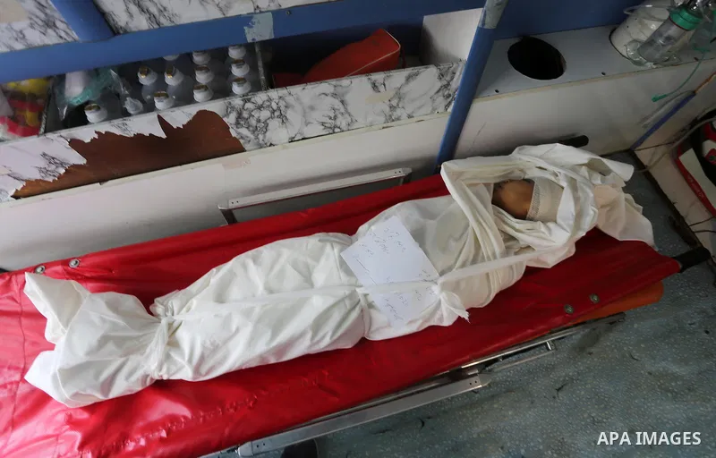 The body of Palestinian Israa Abu Khussa, 6, lies on the bed at the morgue of El-shifa hospital following an Israeli air strike following an Israeli air strike in the northern Gaza strip on March 12, 2016. Israeli planes...