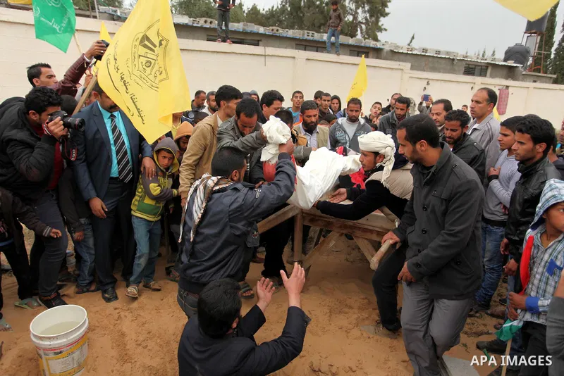 Palestinian mourners burry the body of Israa Abu Khussa, 6, during her funeral on March 12, 2016 in Beit Lahiya in the north of the Gaza strip. Israeli planes struck the bases of the Hamas group's military wing, the Ezze...