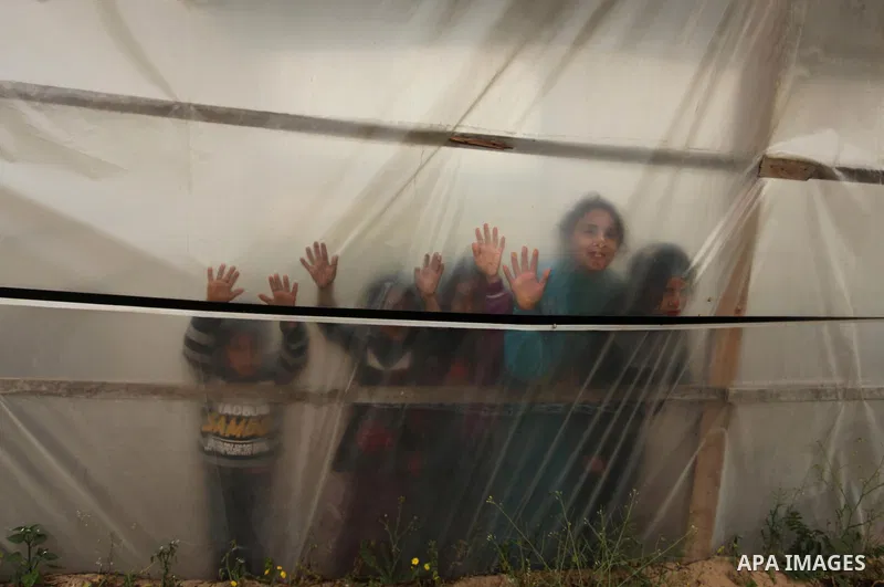 Palestinian childern play outside their house in Beit Lahiya in the north of the Gaza strip on March 12, 2016. Israeli planes struck the bases of the Hamas group's military wing, the Ezzedine al-Qassem Brigades, in the G...